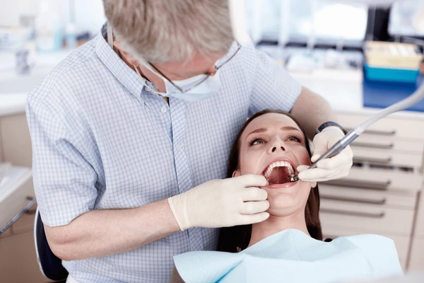 Dentist in Beaumont TX performing a tooth extraction procedure on a patient